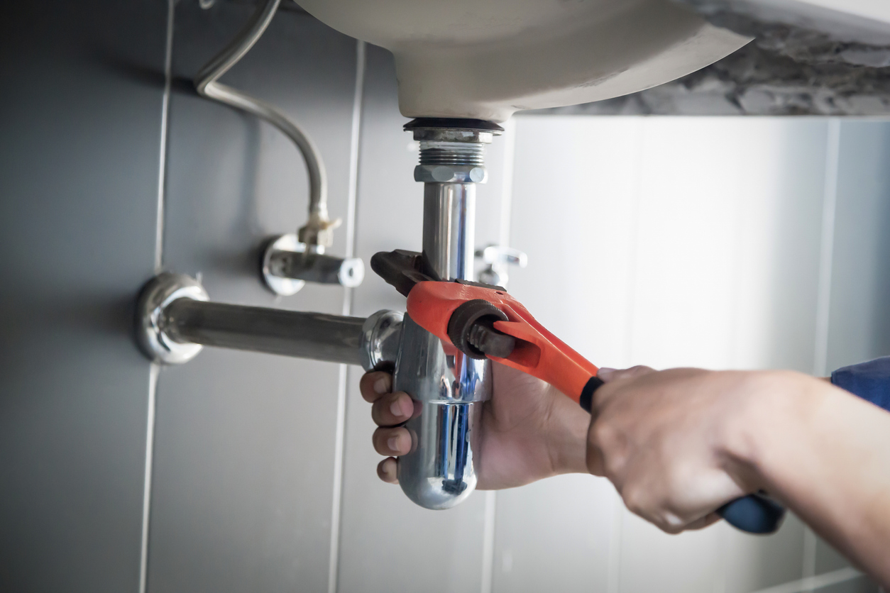 Plumber Repairs Water Pipe Under Sink